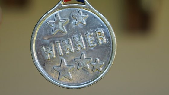 silver medal with winner written on it